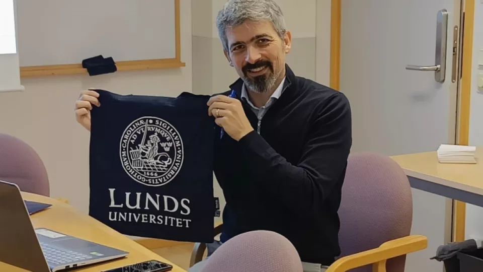 Fotografi på Vincenzo Corvello som håller upp en tygkasse med Lunds universitets logotyp. 