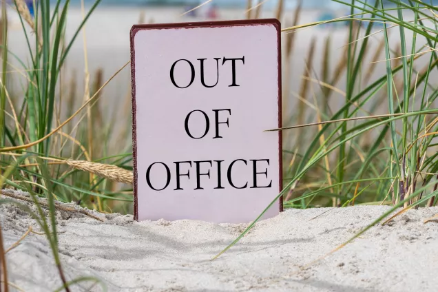 Photo of a sign standing on a sandy beach.