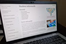 Fotografi på en laptop med informatiks nya webb på. Sidrubriken är "Studera informatik"